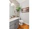 Charming half bathroom with brick accent wall, modern fixtures, and wood flooring at 5388 Frazer Rd, Buford, GA 30518