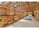 Inside a spacious horse barn with multiple stalls and a well-lit, open layout at 5388 Frazer Rd, Buford, GA 30518