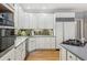 Well-lit kitchen with white cabinetry, gray countertops, and modern appliances at 5388 Frazer Rd, Buford, GA 30518