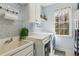 Functional laundry room with a sink, washer, dryer, and ample counter space at 5388 Frazer Rd, Buford, GA 30518