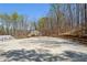 An outdoor horse riding arena with a wooden fence and trees in the background at 5388 Frazer Rd, Buford, GA 30518