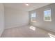 Neutral bedroom with plush carpeting and two windows at 624 Leafy Branch Way, Mcdonough, GA 30253
