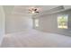 Spacious bedroom with a tray ceiling, ceiling fan, neutral walls, and natural light from multiple windows at 624 Leafy Branch Way, Mcdonough, GA 30253