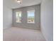Cozy bedroom with two windows and neutral carpet and paint colors at 624 Leafy Branch Way, Mcdonough, GA 30253