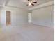 Spacious bedroom with a tray ceiling, ceiling fan, neutral walls, and door to walk-in closet at 624 Leafy Branch Way, Mcdonough, GA 30253