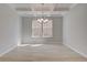 Open dining room with stylish light fixture and large window at 624 Leafy Branch Way, Mcdonough, GA 30253