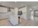 Bright kitchen features a center island, white cabinets, stainless appliances, and light wood-look flooring at 624 Leafy Branch Way, Mcdonough, GA 30253