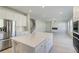 Bright kitchen includes island, stainless refrigerator and flows into the living area with stairs to the second floor at 624 Leafy Branch Way, Mcdonough, GA 30253
