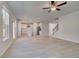 Open concept living room with kitchen, staircase, and light-colored flooring and ceiling fan at 624 Leafy Branch Way, Mcdonough, GA 30253