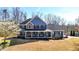 Charming two-story home with a rocking chair front porch, a manicured lawn, and mature trees at 114 Hardwood Ln, Canton, GA 30115