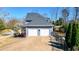 Attached two-car garage with a concrete driveway, fenced yard, and mature landscaping at 114 Hardwood Ln, Canton, GA 30115