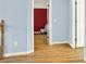 Bright hallway featuring hardwood floors and a view into a room with red accent wall at 114 Hardwood Ln, Canton, GA 30115
