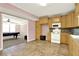 Open kitchen with light wood cabinets, tile flooring, and adjacent living area at 114 Hardwood Ln, Canton, GA 30115