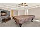 Living room with stone fireplace, ceiling fan, and billiard table at 114 Hardwood Ln, Canton, GA 30115