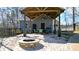 Outdoor living space with vaulted roof, stone pillars, seating area and fire pit at 114 Hardwood Ln, Canton, GA 30115