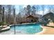 A luxurious pool with a slide and a pool house, set in a beautiful backyard oasis at 114 Hardwood Ln, Canton, GA 30115
