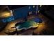 Aerial view of pool with a slide, waterfall features, a mural, and an umbrella lit up at dusk at 114 Hardwood Ln, Canton, GA 30115