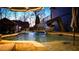 Backyard pool features a slide, fountain features, lighting, and mature trees for a relaxing outdoor space at 114 Hardwood Ln, Canton, GA 30115