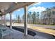 View from the porch showing decorative columns, rocking chairs, and wooded front yard at 114 Hardwood Ln, Canton, GA 30115