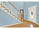 Traditional staircase with hardwood steps and white risers in a light and airy foyer at 114 Hardwood Ln, Canton, GA 30115