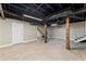 Unfinished basement with painted ceiling, exposed duct work, wooden support beams, and stairs to upper level at 3263 Dodson Dr, Atlanta, GA 30344