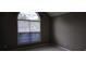Neutral bedroom with a large window bringing in natural light at 5763 Dexters Mill Pl, Buford, GA 30518