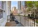 Balcony with black metal railing, wooden table and chairs, overlooking the street and high rise buildings at 1078 Piedmont Ne Ave # 203, Atlanta, GA 30309