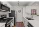 Well-lit kitchen with stainless steel appliances, white cabinetry, subway tile backsplash, and a decorative red rug at 1078 Piedmont Ne Ave # 203, Atlanta, GA 30309
