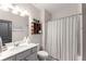 Cozy bathroom with white vanity, shower with curtains, and neutral walls at 125 Whitman Grv, Fayetteville, GA 30215
