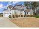Charming home featuring a two-car garage, stone accents, and lush landscaping at 125 Whitman Grv, Fayetteville, GA 30215
