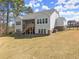 The back of a two-story home showcases a covered porch, stairs, and a well-maintained yard, complemented by mature trees at 125 Whitman Grv, Fayetteville, GA 30215