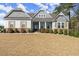Attractive home with welcoming porch, stone accents, shutters, and well-manicured lawn at 125 Whitman Grv, Fayetteville, GA 30215
