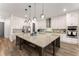 Modern kitchen with a granite island, pendant lighting, stainless steel appliances, and plenty of cabinet space at 125 Whitman Grv, Fayetteville, GA 30215