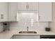 Close-up of a modern kitchen with white cabinets, a stainless steel sink, and a subway tile backsplash at 2030 Main Nw St # 207, Atlanta, GA 30318