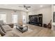 Bright living room featuring modern entertainment center, fan, and hardwood floors at 2030 Main Nw St # 207, Atlanta, GA 30318