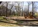 Community playground featuring slides, climbing structures, and swings, set among mature trees at 2030 Main Nw St # 207, Atlanta, GA 30318