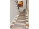 Carpeted stairway with stained handrail, white risers, and decorative artwork at 2030 Main Nw St # 207, Atlanta, GA 30318