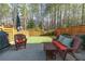 Cozy back patio with a wicker seating area, a grill, and a view of the grassy lawn at 5018 Towneship Creek Rd, Roswell, GA 30075