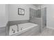 Modern bathroom features a soaking tub, a separate shower, and neutral toned finishes at 5018 Towneship Creek Rd, Roswell, GA 30075