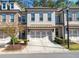 Charming townhome featuring a modern brick exterior, a two-car garage, and manicured landscaping at 5018 Towneship Creek Rd, Roswell, GA 30075
