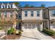 Charming brick townhome featuring a two-car garage and meticulously landscaped front yard at 5018 Towneship Creek Rd, Roswell, GA 30075