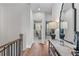Upstairs hallway with hardwood floors and a view of a home office and seating area at 5018 Towneship Creek Rd, Roswell, GA 30075