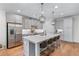 Well-lit kitchen boasting a center island with bar stools, stainless steel appliances, and gray cabinetry at 5018 Towneship Creek Rd, Roswell, GA 30075
