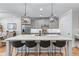 Bright kitchen with an island and barstool seating, stainless steel appliances, and modern light fixtures at 5018 Towneship Creek Rd, Roswell, GA 30075