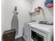 Well-equipped laundry room featuring modern washer, dryer, storage, and ironing station for efficient household tasks at 5018 Towneship Creek Rd, Roswell, GA 30075