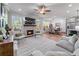 Open-concept living space with a fireplace, comfortable seating, and a view into the dining room and kitchen at 5018 Towneship Creek Rd, Roswell, GA 30075