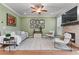 Inviting living room featuring green walls, neutral furniture, stylish decor, and a fireplace at 5018 Towneship Creek Rd, Roswell, GA 30075