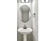 Half bathroom featuring a pedestal sink, oval mirror, and modern fixtures at 7229 Georges Way, Morrow, GA 30260