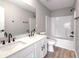 Bathroom with dual sink vanity, white cabinets, and a large mirror; tub and shower combo at 7229 Georges Way, Morrow, GA 30260