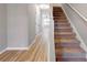 Hallway with stairs and hard surface flooring, leading to a bedroom with natural light from a large window at 7229 Georges Way, Morrow, GA 30260